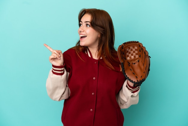 Young redhead woman playing baseball isolated on blue background intending to realizes the solution while lifting a finger up