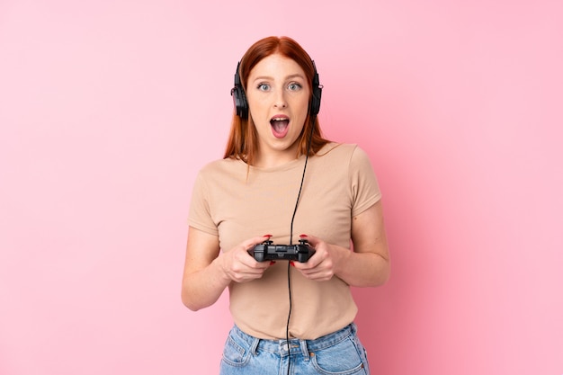 Young redhead woman playing at videogames