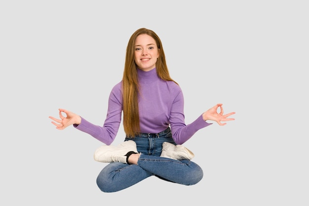 Young redhead woman sitting isolated cut out