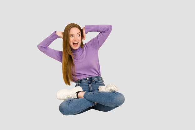 Young redhead woman sitting isolated cut out