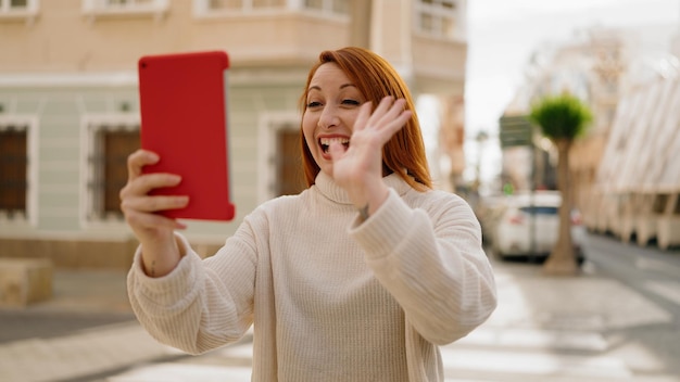 Young redhead woman smiling confident having video call at street