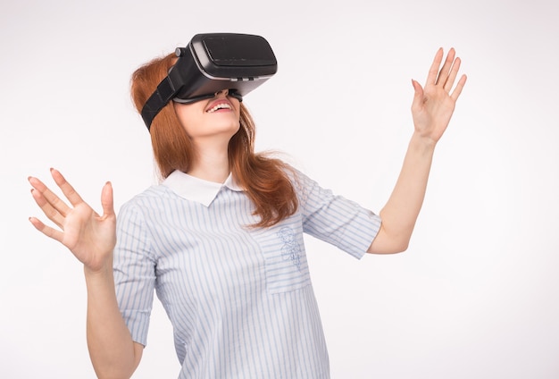 Young redhead woman using glasses of virtual reality.