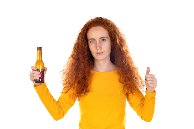 Foto giovane donna rossa sopra la parete bianca che tiene una bottiglia di birra felice con un grande sorriso