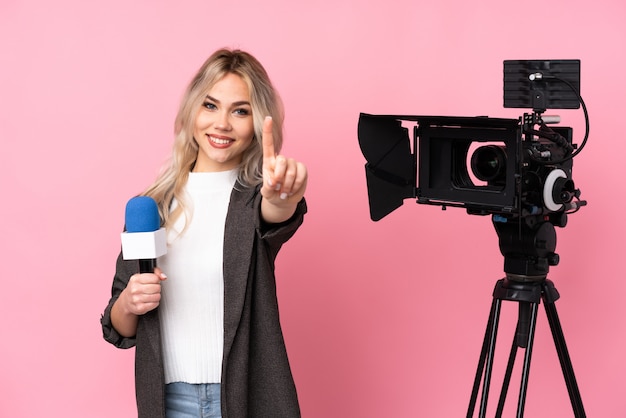 Young reporter woman over isolated wall