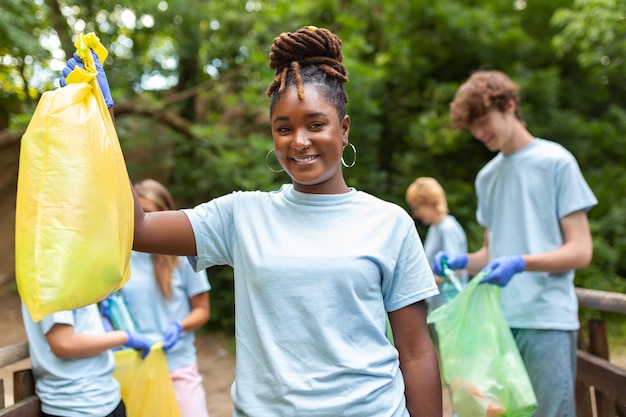 Young responsible people doing community charity work in the park Group of people cleaning together in public park saving the environment