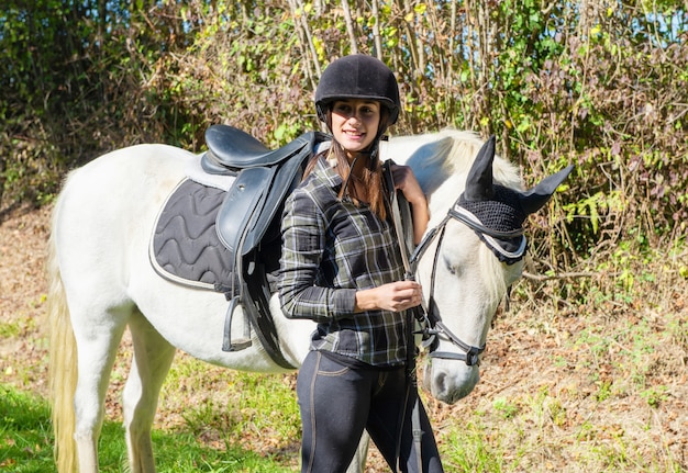 Young rider woman with white horse