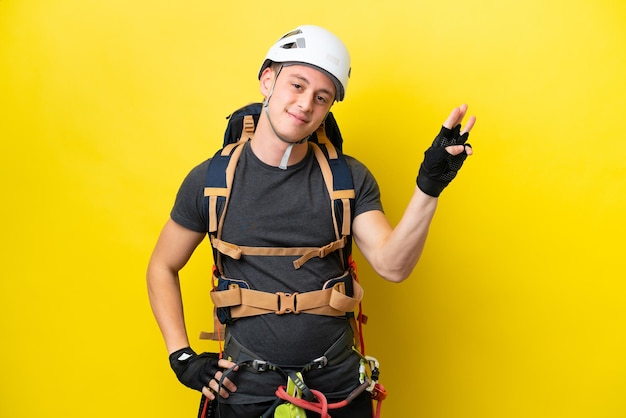 Young rock climber Brazilian man happy and counting three with fingers