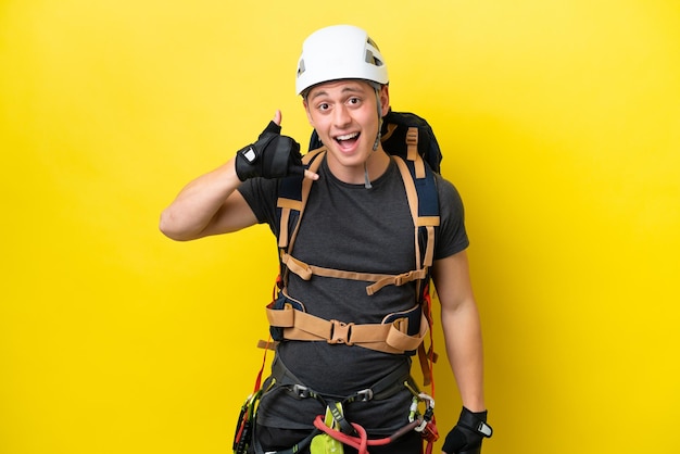 Young rock climber Brazilian man making phone gesture Call me back sign