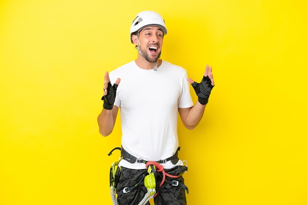 Young rock climber man isolated on yellow background with\
surprise facial expression