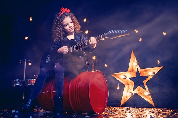 Young rock girl playing the electric guitar