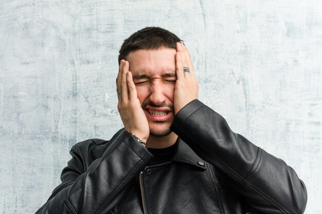 Young rocker man whining and crying disconsolately.