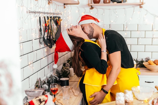 Young romantic couple standing on kitchen kissing and hugging