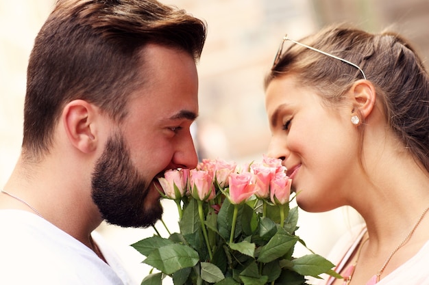 young romantic couple with flowers in the city