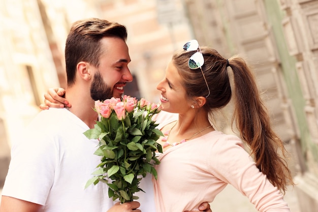 young romantic couple with flowers in the city
