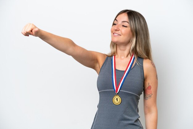 Foto giovane donna rumena con medaglie isolate su sfondo bianco che dà un pollice in alto gesto