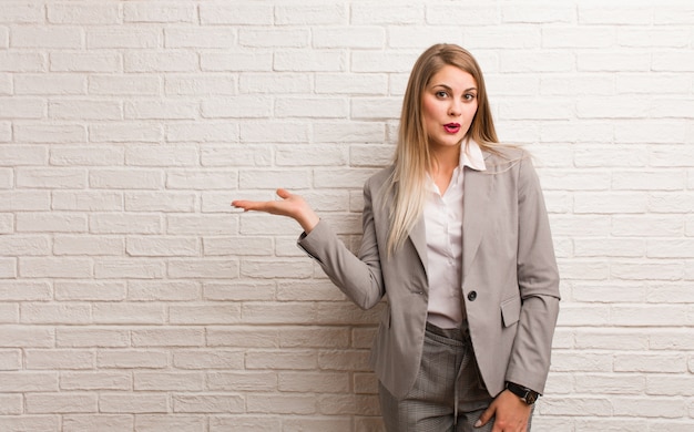 Young russian business woman holding something on palm hand