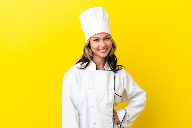 Young Russian chef girl isolated on yellow background laughing