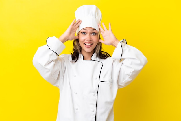 Young Russian chef girl isolated on yellow background with surprise expression