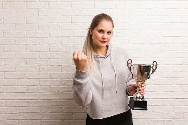 Young russian fitness woman holding a trophy