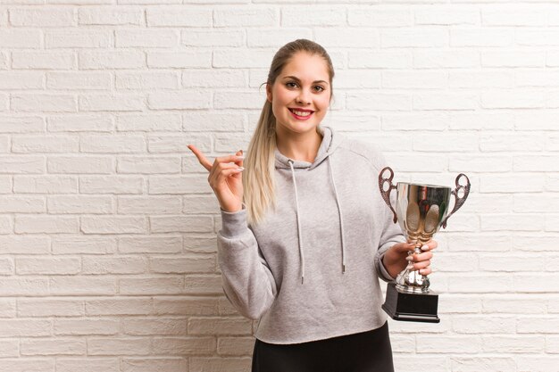 Young russian fitness woman holding a trophy