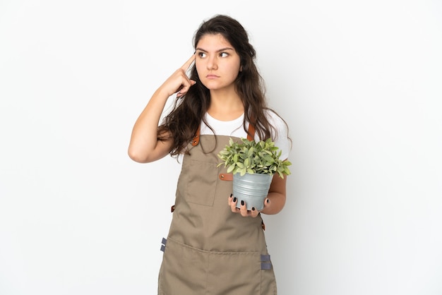 Young Russian gardener girl holding a plant isolated