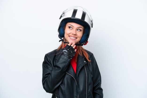 笑顔で見上げる白い背景で隔離のオートバイのヘルメットと若いロシアの女の子