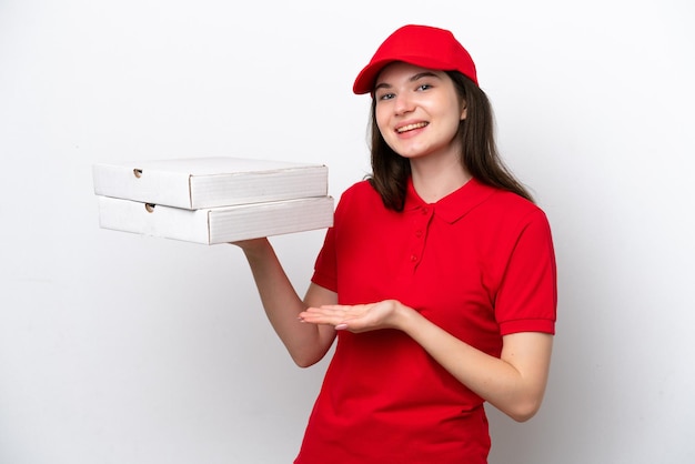 Young Russian pizza delivery picking up pizza boxes isolated on white background extending hands to the side for inviting to come