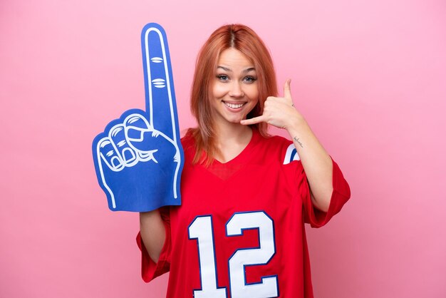 Young Russian rugby fan girl isolated on pink background making phone gesture Call me back sign