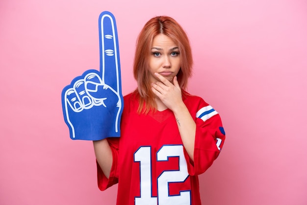 Young Russian rugby fan girl isolated on pink background thinking