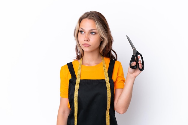 Young Russian seamstress girl isolated on white background looking to the side