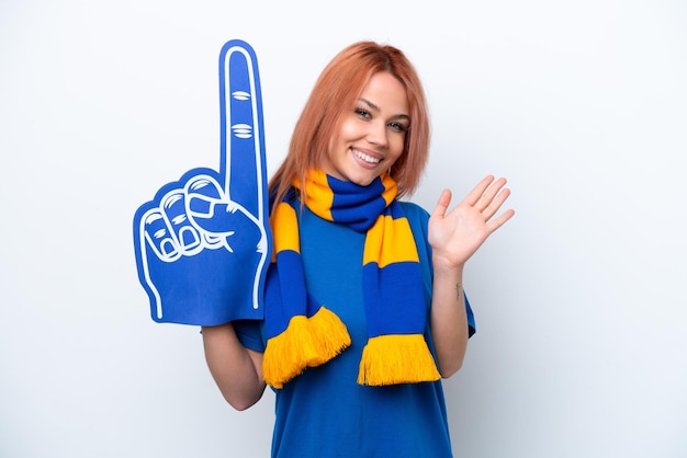 Young Russian sports fan girl isolated on white background saluting with hand with happy expression