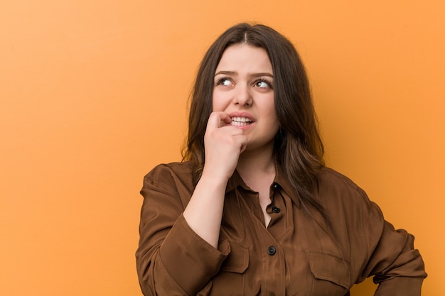 Young russian woman biting fingernails, nervous and very anxious.