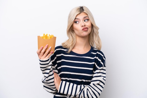 Young Russian woman catching french fries isolated on white background with sad expression