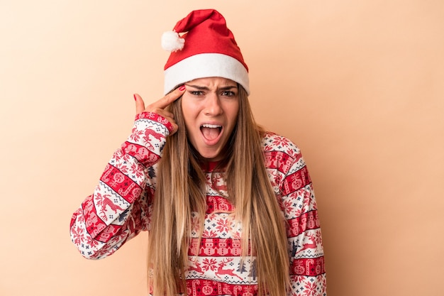 Young Russian woman celebrating Christmas isolated on beige background showing a disappointment gesture with forefinger.