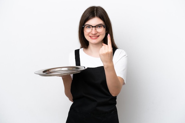 Молодая русская женщина-повар с подносом на белом фоне делает предстоящий жест