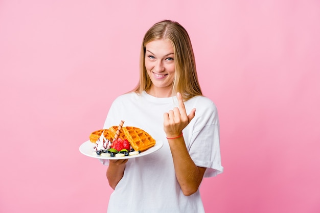 Young russian woman eating a waffle isolated