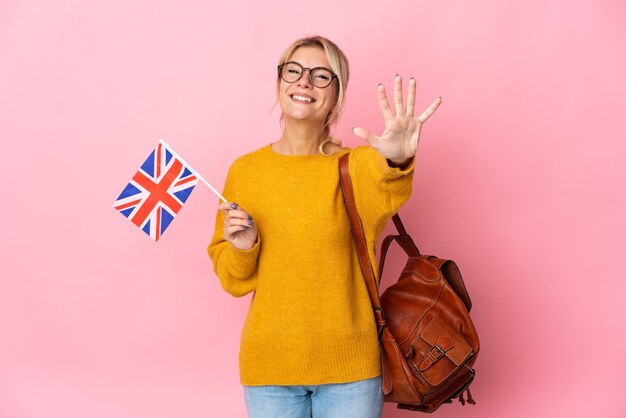 손가락으로 5 세 분홍색 배경에 고립 된 영국 국기를 들고 젊은 러시아 여자