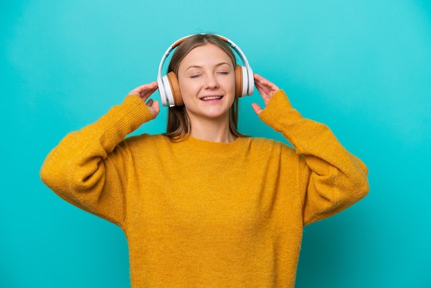 Young Russian woman isolated on blue background listening music and singing