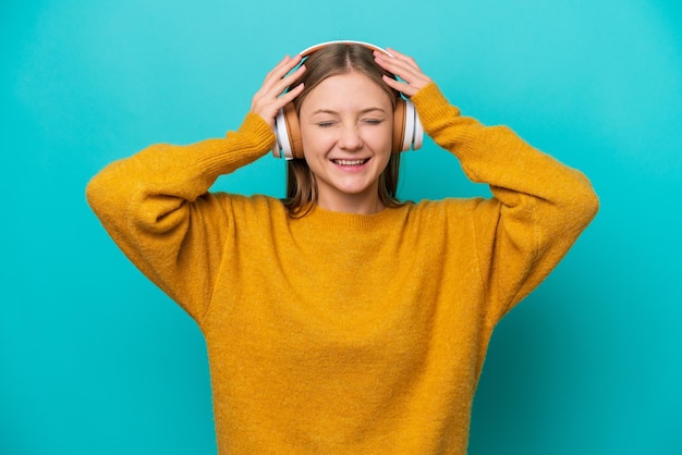 音楽を聴いて青い背景で隔離の若いロシアの女性