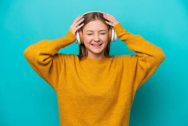 Молодая русская женщина изолирована на синем фоне, слушая музыку