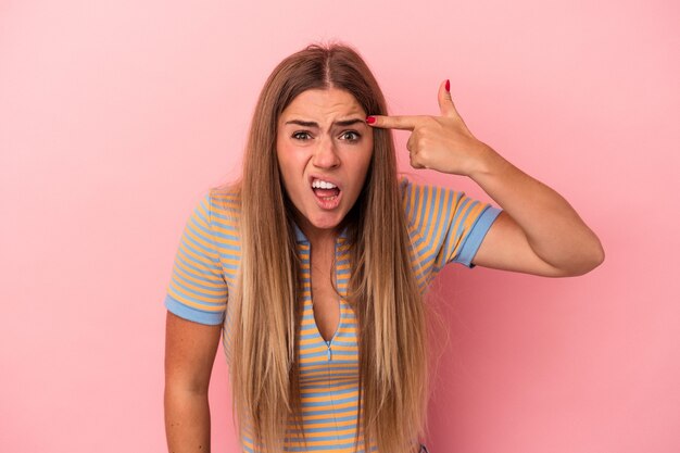 Young Russian woman isolated on pink background crossing fingers for having luck