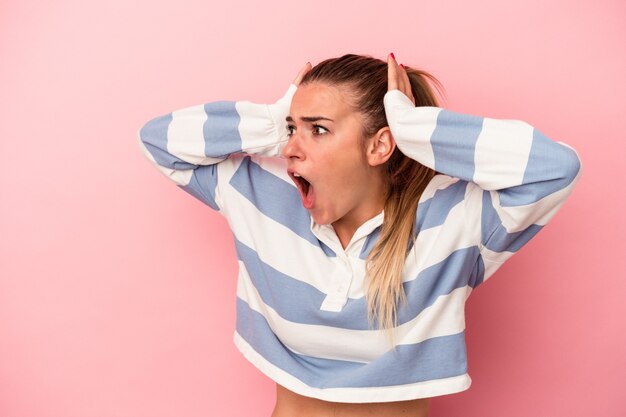 Young russian woman isolated on pink background crying, unhappy with something, agony and confusion concept