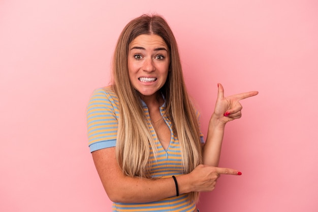Photo young russian woman isolated on pink background folding lips and holding palms to send air kiss.