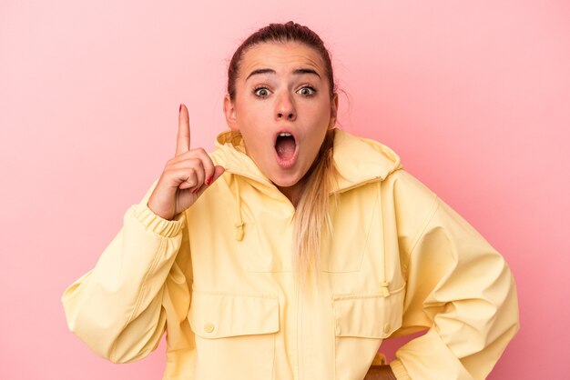 Young Russian woman isolated on pink background having an idea, inspiration concept.