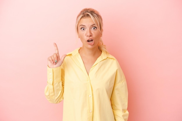 Young Russian woman isolated on pink background having an idea inspiration concept