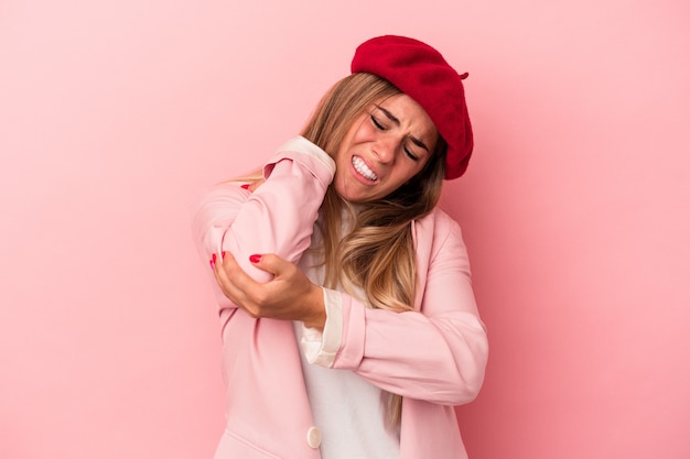 Young Russian woman isolated on pink background having a shoulder pain.