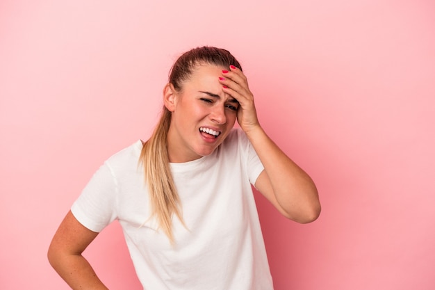 Giovane donna russa isolata su sfondo rosa gioiosa ridendo molto. concetto di felicità.