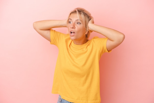 Young Russian woman isolated on pink background screaming, very excited, passionate, satisfied with something.