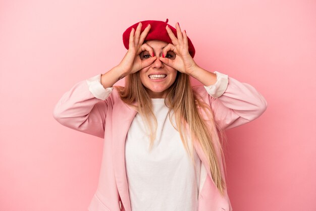 Young Russian woman isolated on pink background showing rock gesture with fingers