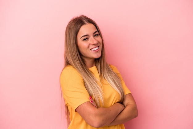 Young Russian woman isolated on pink background showing victory sign and smiling broadly.